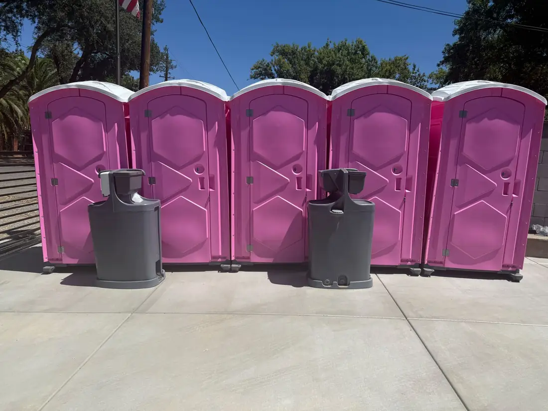 Portable hand-washing stations beside porta potties